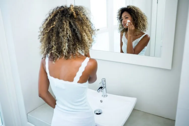 Beauty maintenance - Young woman cleaning her face